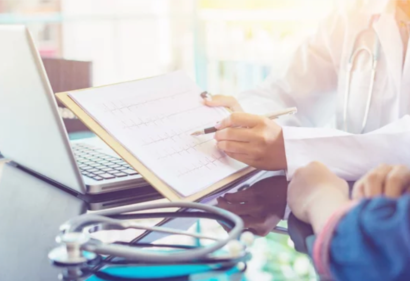 Ein Arzt schreibt mit einem Stift auf einen Diagnosezettel mit Kurve