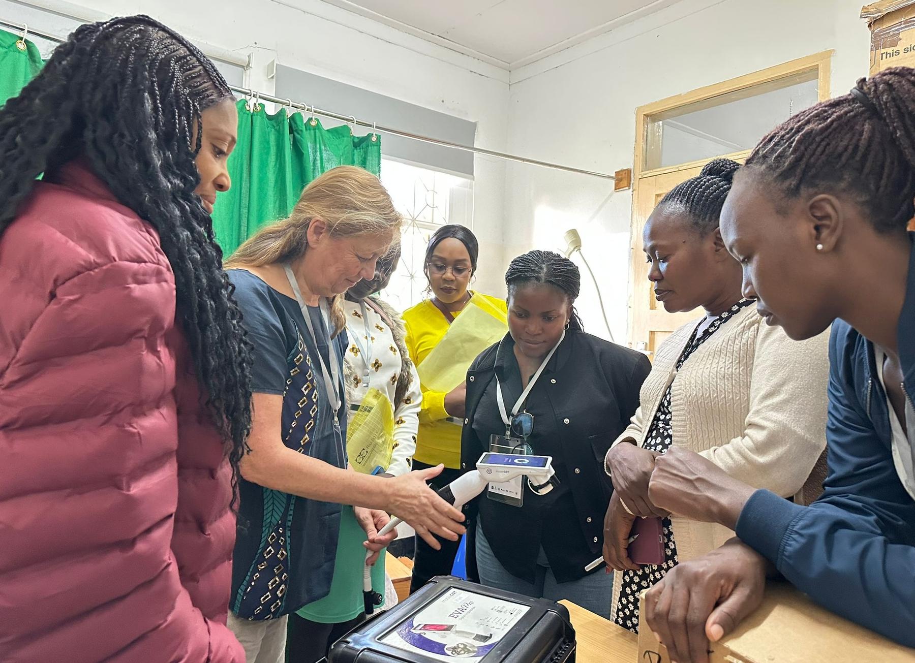 Prof. Inge Kroidl explains the mobile colposcope to the participants.