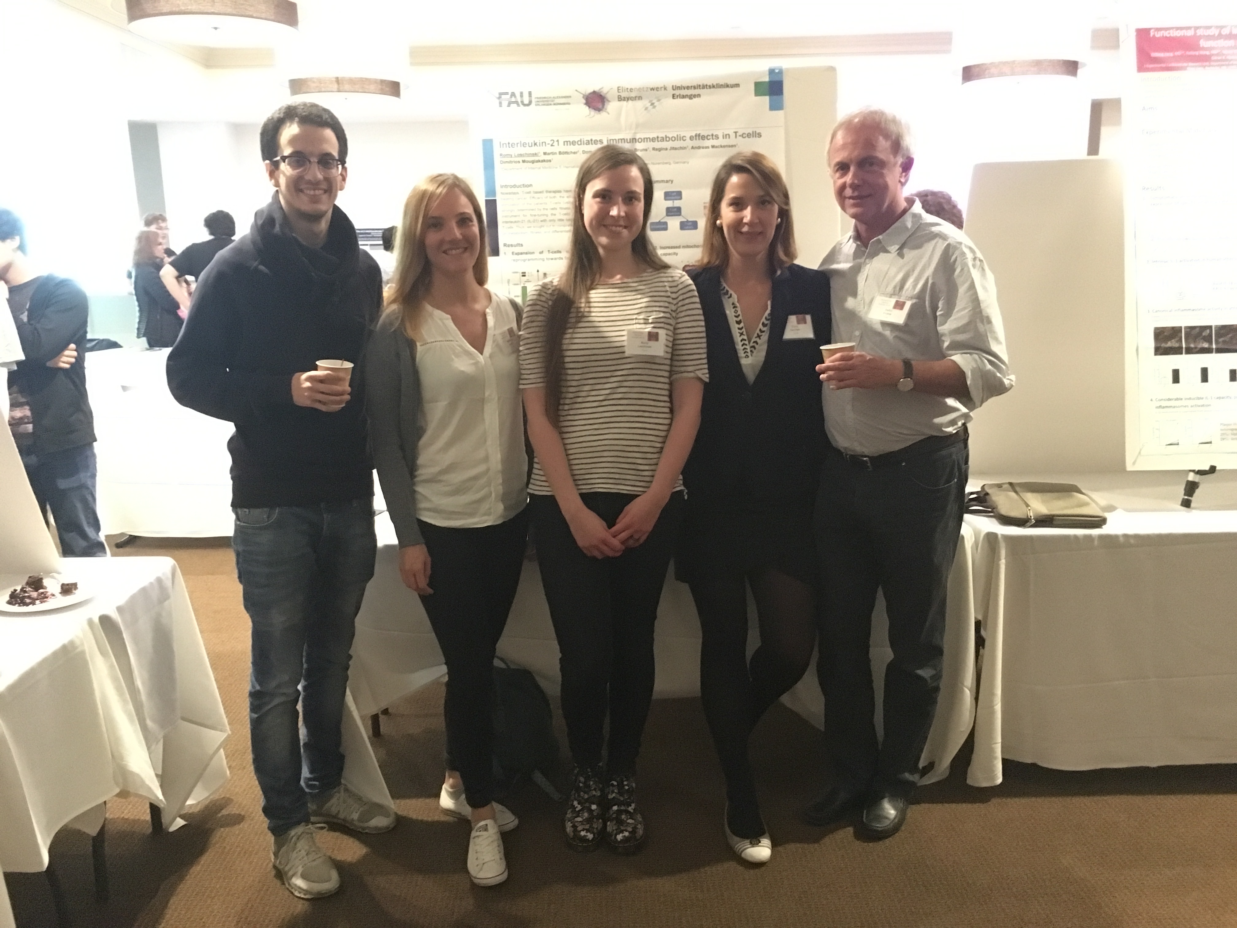 Eine Gruppe von 5 Menschen darunter 2 Professoren und 3 Doktoranden auf einem Event