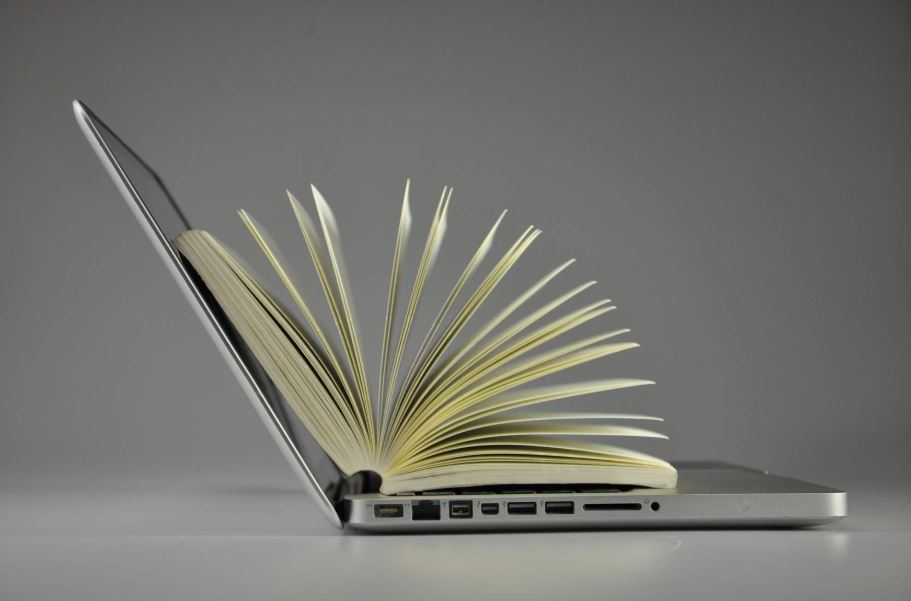 Aufgeklappter Laptop mit einer Papieraktenmappe als Symbol für Suche in verschiedenen Anwendungen