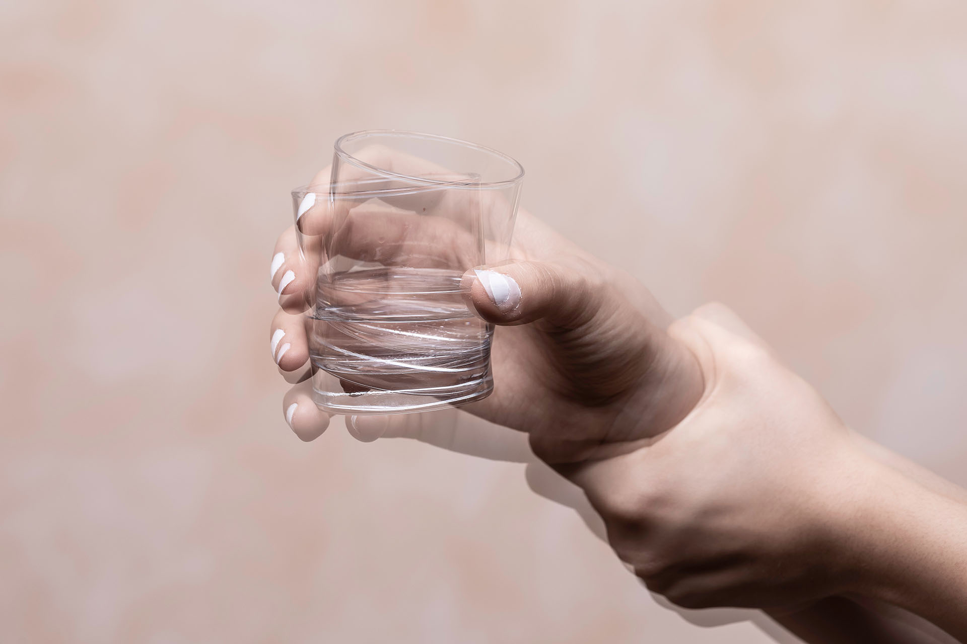 Stilbild Parkinson: Zitternde Hand mit Glas