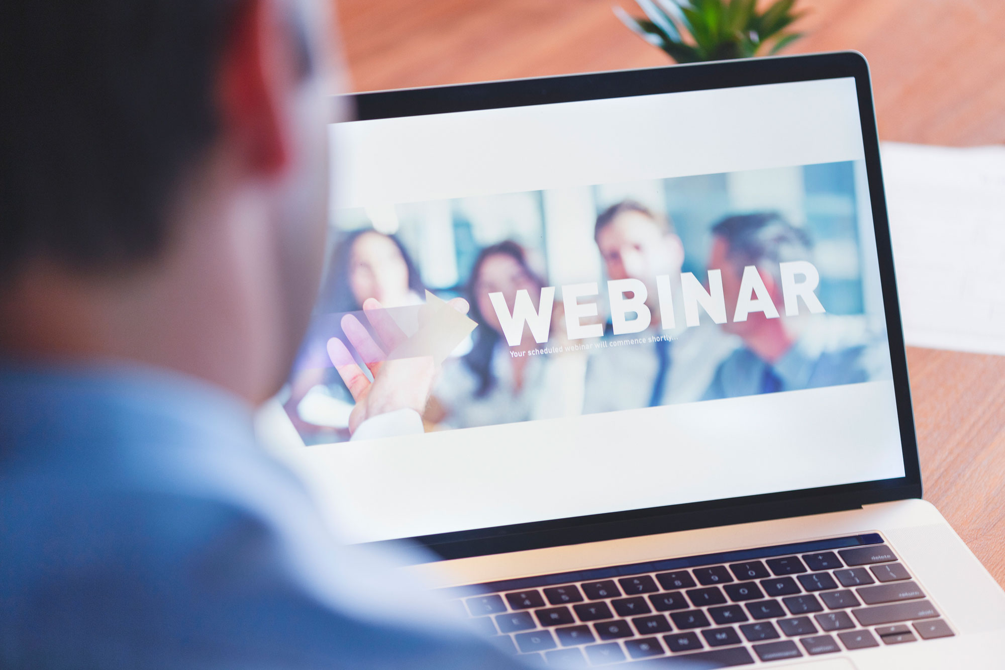Mann vor Laptop, der sich gerade zu einem Webinar anmeldet